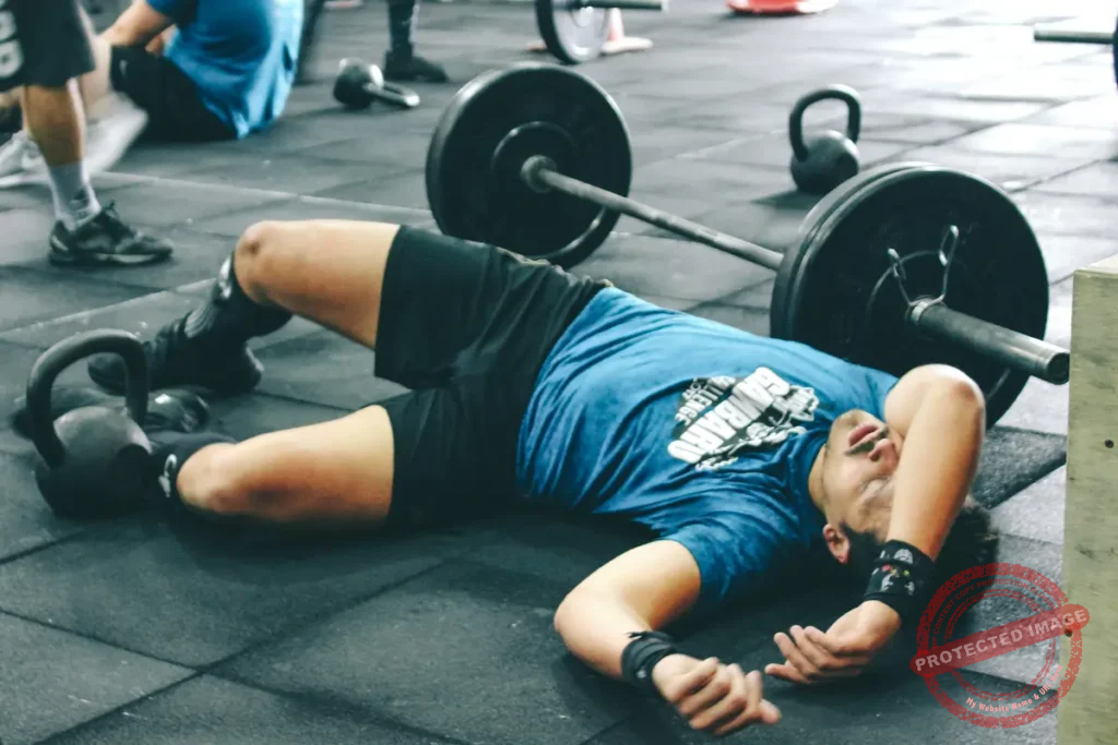Canva man lying on rubber mat near barbell inside the gym